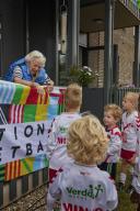 Oudere dame met jonge voetballers tijdens De Nationale Voetbaldag